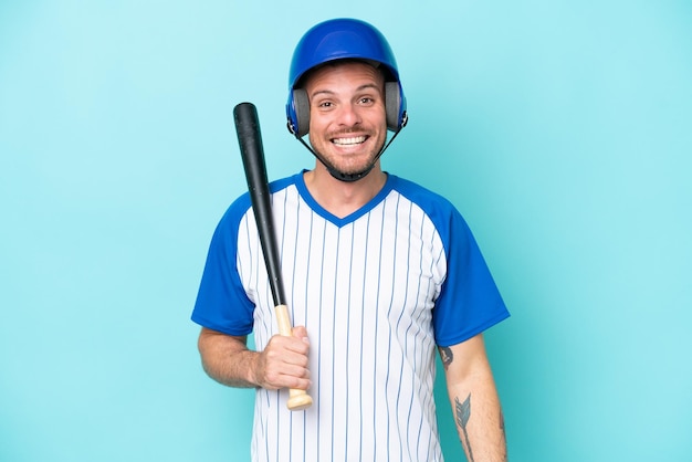 Giocatore di baseball con casco e pipistrello isolato su sfondo blu con espressione facciale a sorpresa