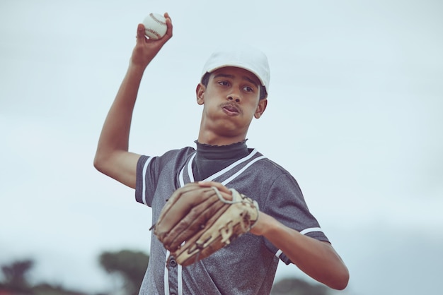 Baseball sports and fitness with a man athlete throwing a ball during a game or match outside workout training and exercise with a male baseball player playing a competitive sport for health