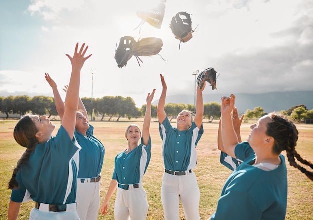 Baseball team and women celebration winner and excited after winning a game and throwing gloves in the air Teamwork collaboration and support with happy group on teens in a sports club outdoor