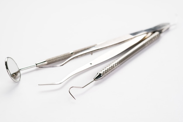 Basic dentist tools on white background.