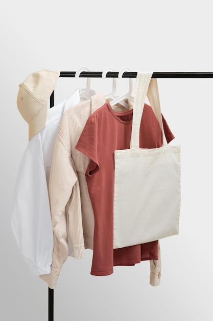 Basic womens clothes and eco bag on white background Woman collection of clothes on a rack S