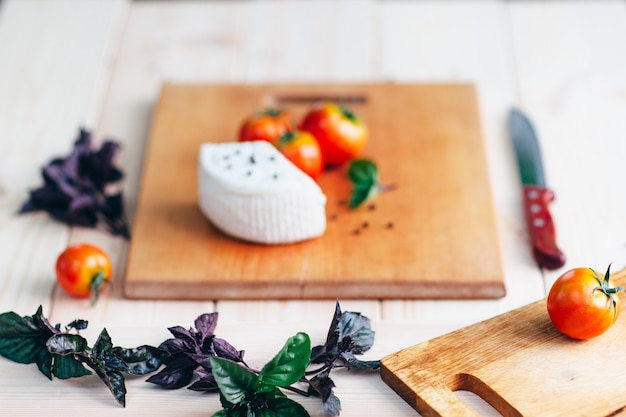 Basil cheese tomatoes on kitchen board