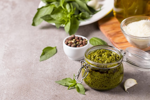 Basil pesto sauce in a jar Ingredients for cooking cheese parmesan garlic olive oil