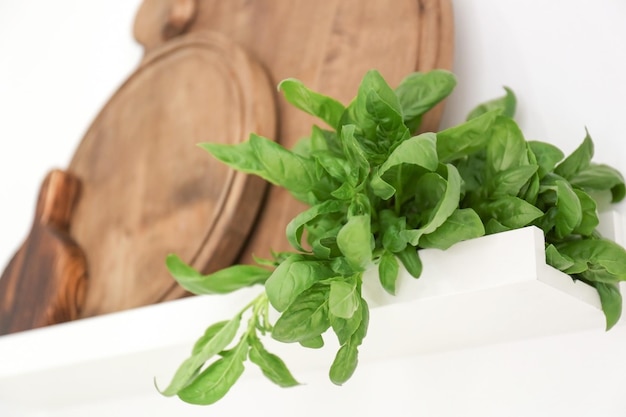 Basil and wooden boards on shelf