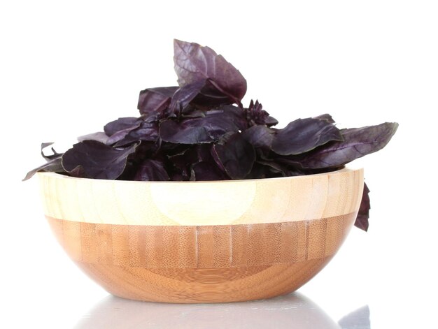 Basil in a wooden bowl isolated on white