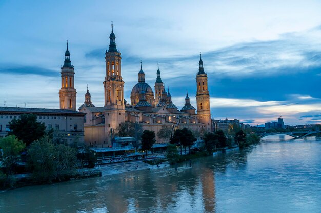 Photo basilica del pilar by the river at dusk zaragoza