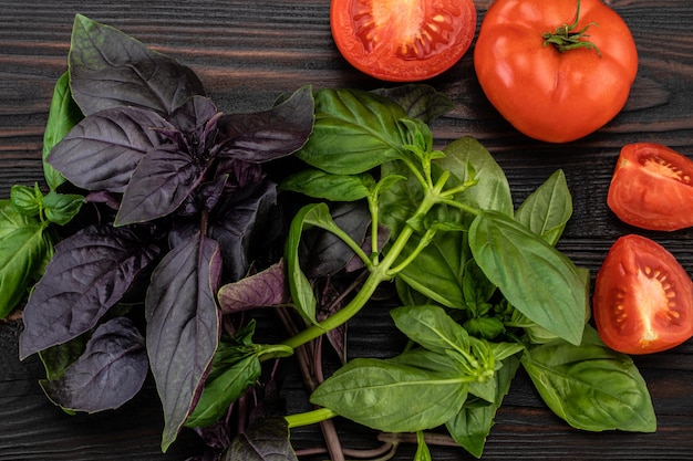 Basilicumbladeren en tomaten op houten achtergrond. Ruimte kopiëren.