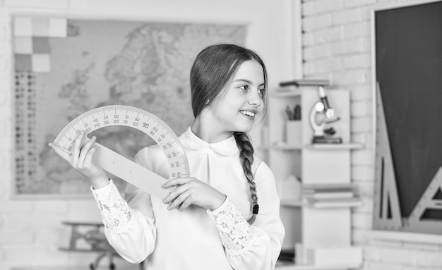 Basisschool wiskunde of wiskunde Wetenschap en technologie Wiskunde is belangrijk Klein kind houdt liniaal vast voor wiskundeles Schattig klein schoolmeisje met geometrische tool voor wiskunde