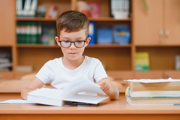 Basisschooljongen bij klaslokaal die nieuwe ideeën voor schoolwerk probeert te vinden.