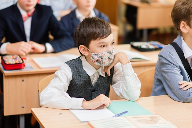 Basisschoolkinderen die in boeken in de klas schrijven