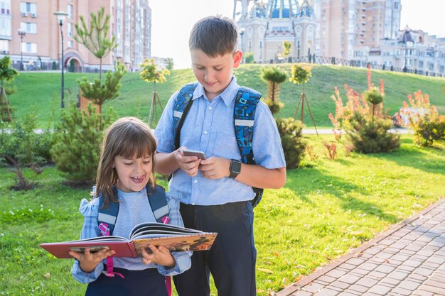 Basisschoolleerlingen met een leerboek buitenshuis Terug naar school