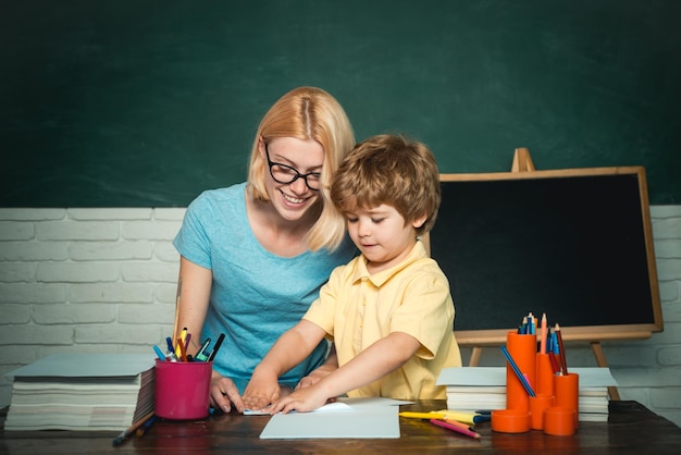 Basisschoolonderwijs en leren kind concept leraar helpen jonge jongen met les educati