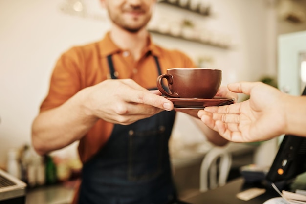 Basita geeft cappuccino aan klant