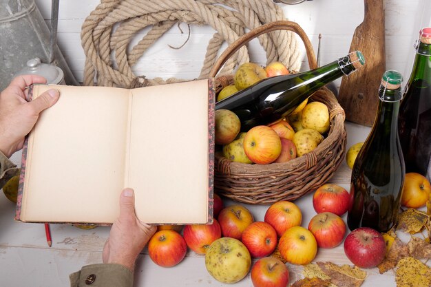 Basket of apples, bottles of cider and old notebook