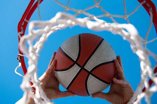 Foto campionato di basket con pallacanestro il basket come simbolo di sport e fitness di un'attività di squadra per il tempo libero giocando a mani e basket