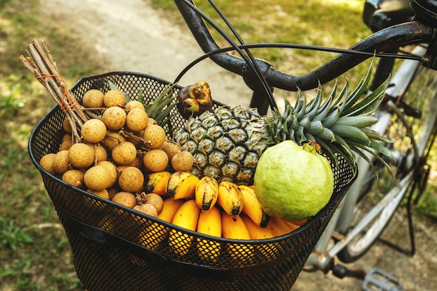 Basket on the bicycle full of different exotic fruits