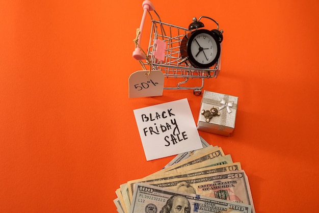 Basket clock gifts with discounts and dollars lie isolated on an orange background