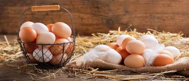 Basket of colorful fresh eggs on wooden table