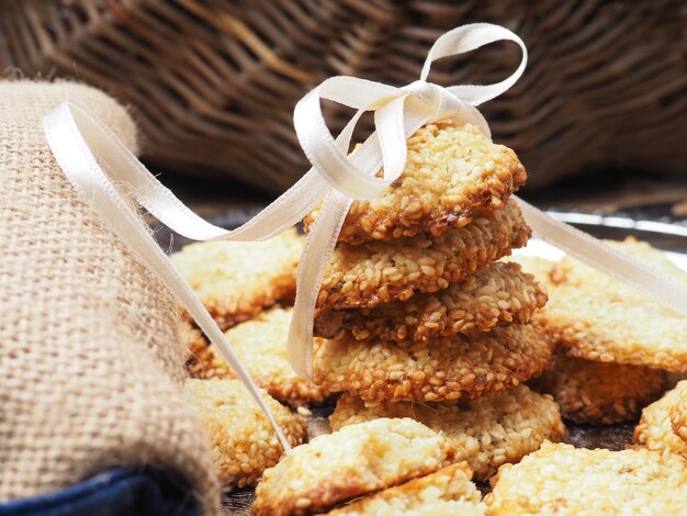 A basket of cookies with a white ribbon tied around the top.