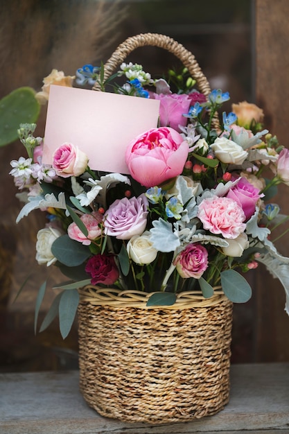 basket filled with assorted colorful flowers and a notecard