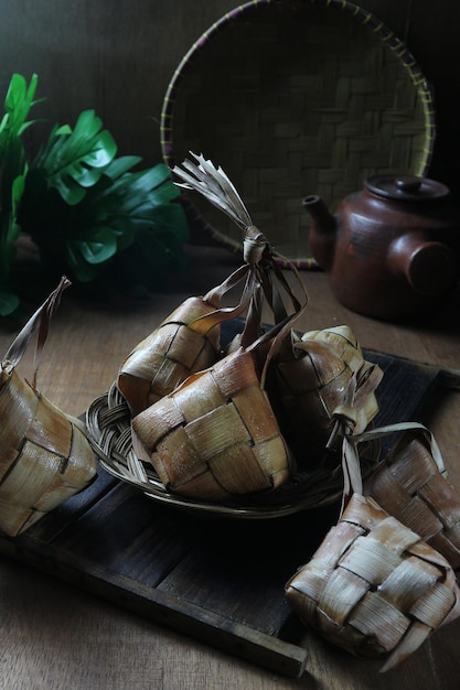 A basket of fish wrapped in bamboo is on a table.