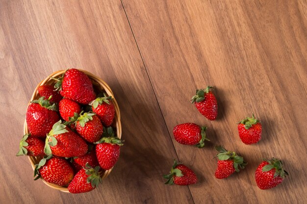 Basket of fresh strawberries on wooden background