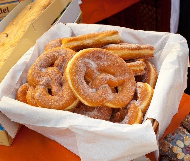 Basket of fried pretzel with sugar.