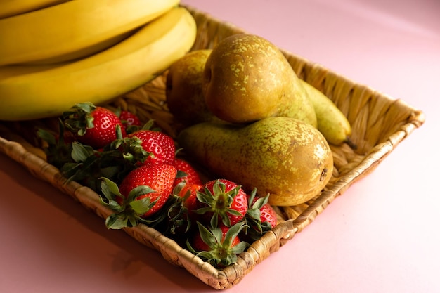 A basket of fruit with bananas and strawberries on it