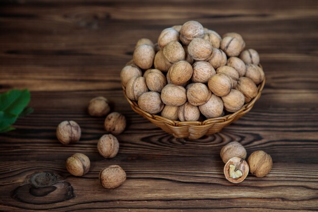 A basket full of walnuts on a wooden background