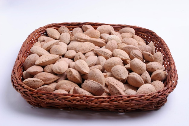 A basket of inshell almonds is shown on a white background