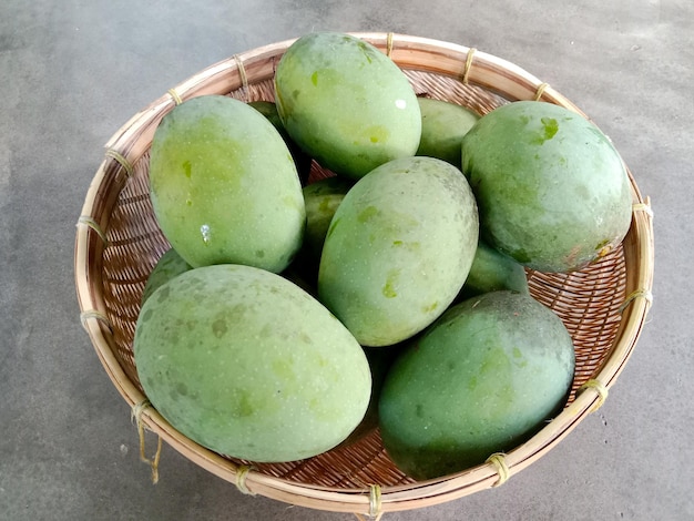 Foto un cesto di kweni su un tavolo. kweni o mangifera odorata. frutta kweni in un cesto.