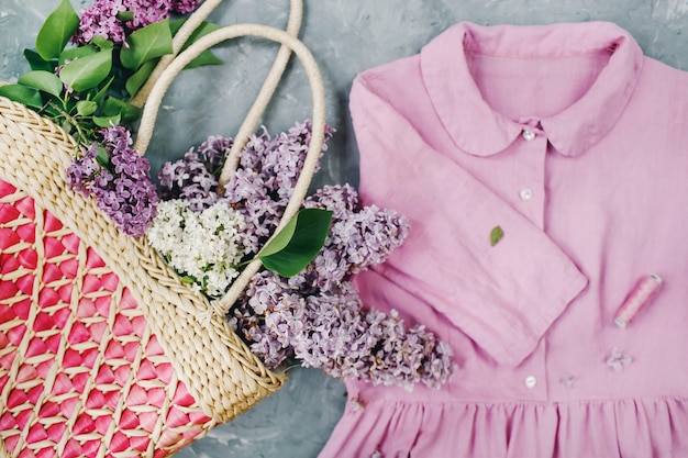 Basket of lilacs flowers and pastel pink summer dress