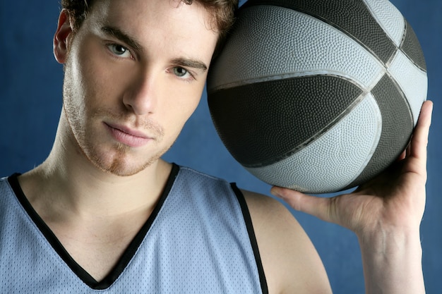 Basket player young man over blue