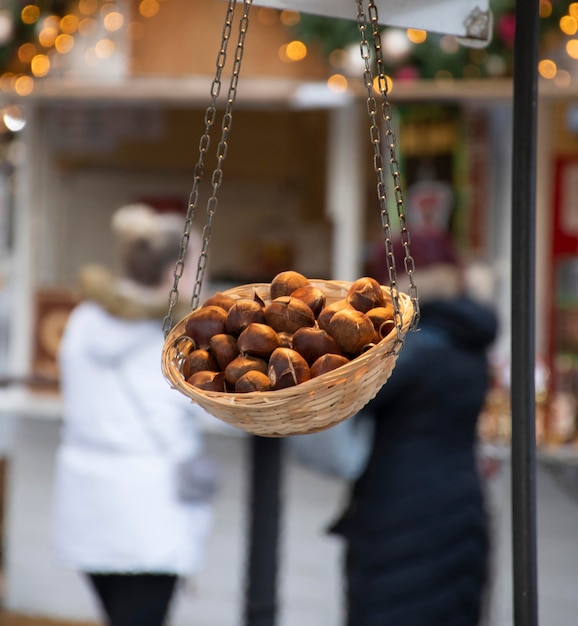 Корзина с сырым фундуком висит на рождественской уличной ярмарке европейской зимой