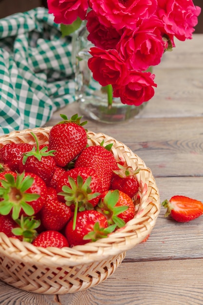 Basket of strawberry harvest on wooden table close up