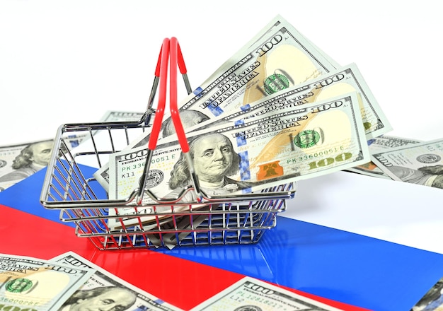 Basket for a supermarket with us dollars on the background of the russian tricolor flag