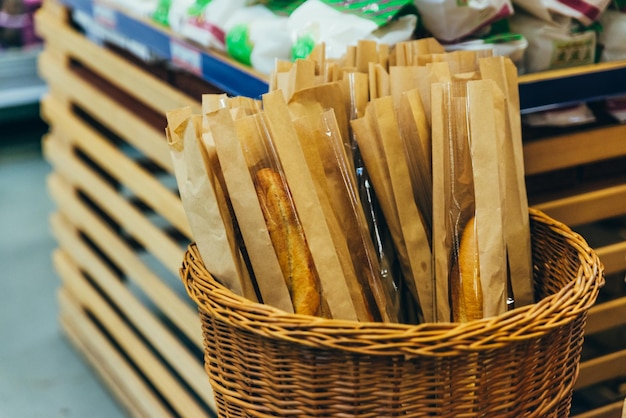 Basket with baguette in store grocery shopping concept