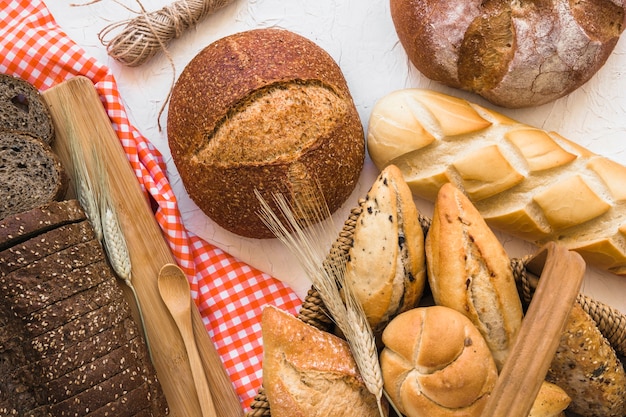 Basket with buns near loaves of bread