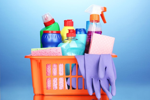 Basket with cleaning items on blue background