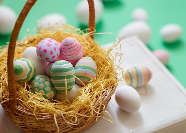 Basket with colorful Easter eggs, close up photo.