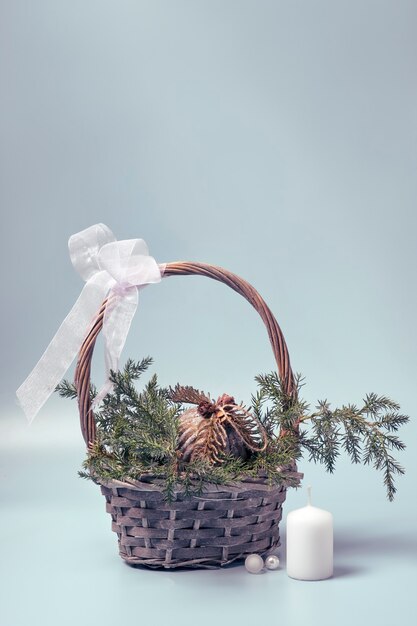 Photo basket with coniferous branches and a christmas ball in rustic style. christmas decor made of ecological materials.