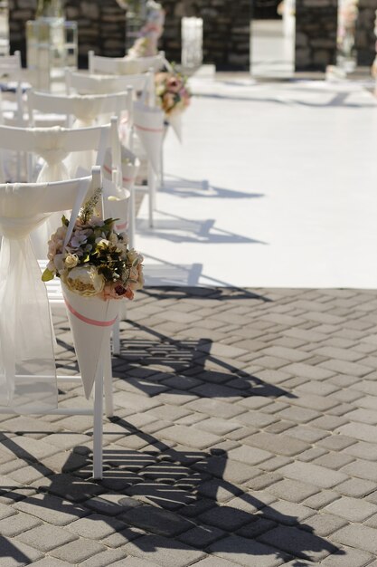 Basket with flowers on the back of a chair at a wedding ceremony, selective focus