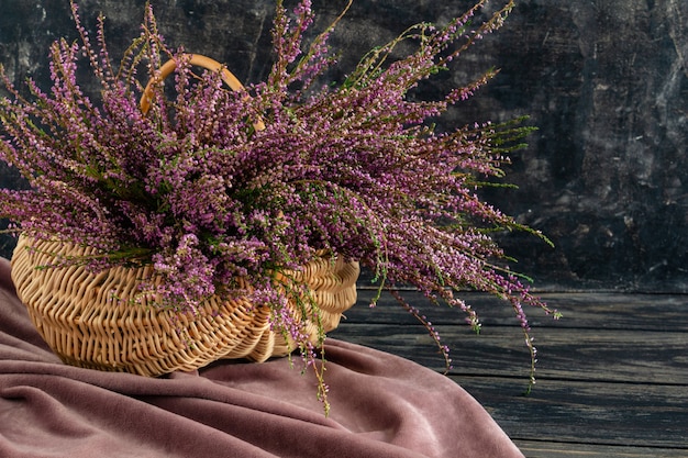 Basket with flowers on a black background lilac heather