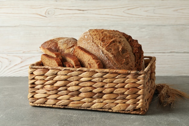 Basket with fresh bread on gray table