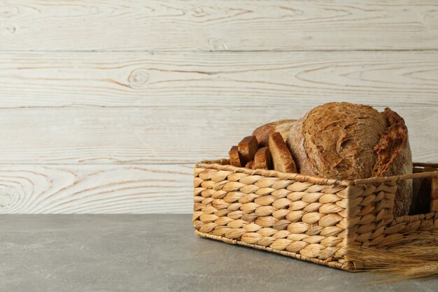 Basket with fresh bread on gray table