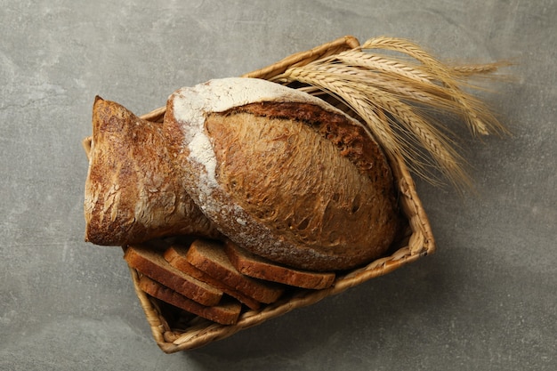 Basket with fresh bread on gray table