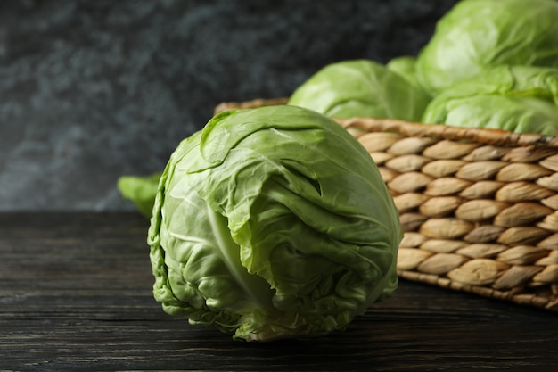 Basket with fresh cabbage on wooden table