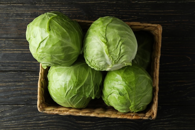 Basket with fresh cabbage on wooden table