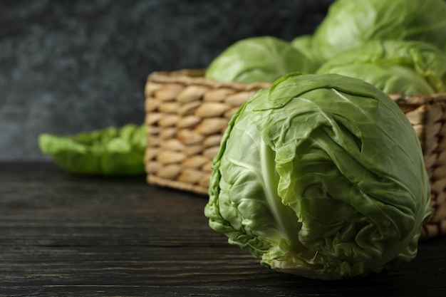 Basket with fresh cabbage on wooden table