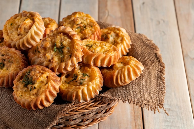 Basket with fresh muffins on wooden background Homemade cakes with vegetables and cheese Recipe for autumn seasonal dish